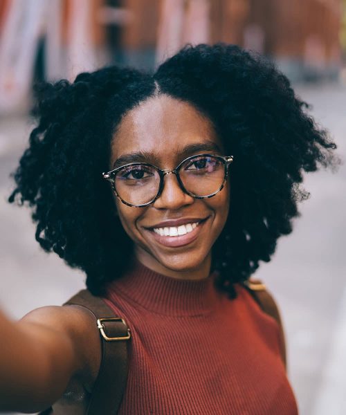 a person wearing glasses and smiling at the camera
